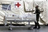 Voják pomáhá v polní nemocnici v Praze.