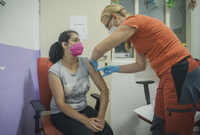 Žena dostává vakcínu v nízkoprahovém centru v Ralsku - Náhlově na Českolipsku, kam 19. srpna 2021 dorazil mobilní očkovací tým, který nabízí očkování proti covidu-19 ve vyloučených lokalitách v Libereckém kraji.