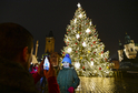 Dívka se fotí 26. listopadu 2021 před rozsvíceným vánočním stromem na Staroměstském náměstí v Praze. Stejně jako před rokem se kvůli koronaviru rozsvícení muselo obejít bez tradiční velké slavnosti.