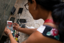 Žena kontroluje nabití na svém telefonu kvůli nedostatku elektřiny v důsledku hurikánu Ian v Havaně na Kubě, čtvrtek 29. září 2022. 