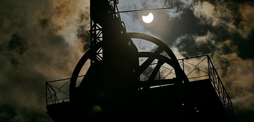 Částečné zatmění Slunce nad historickou těžní věží bývalého černouhelného dolu Simson ve Zbýšově na Brněnsku. 25. října 2022.