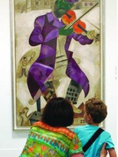 Perly 20. století. Návštěvníci současné výstavy sbírek Guggenheimovy nadace před obrazem malíře Marka Chagalla.