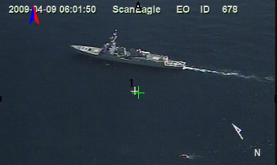 Válečná loď USA a člun s piráty. Záběr z bezpilotního letounu.
