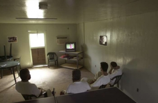 Vězni na Guantánamu sledují televizi.