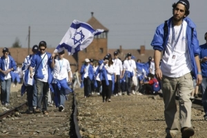 Židovské vlajky před branami Osvětimi.