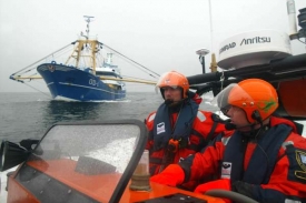 Kontroloři se blíží k rybářské lodi v Severním moři.