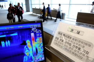 Měření teploty těla pasažerů na letišti v Soulu.