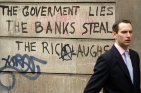 Vláda lže, banky kradou a bohatí se smějí... Nápis na zdi.
