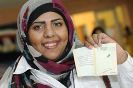 Kuvajťanka ukazuje potvrzení o tom, že hlasovala ve volbách.