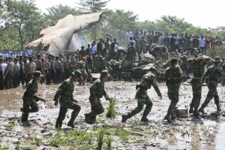 Záchranáři hledají oběti leteckého neštěstí v rýžovém poli.