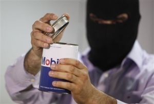Maskovaný libanonský policista ukazuje zabavený vysílač.