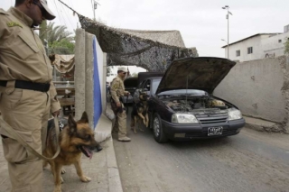 Psi hledají na jednom z bagdádských checkpointů výbušniny.