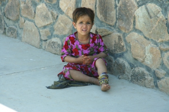 Afghánská holčička u zdi.