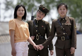Usměvy v čase krize. Vojačky KLDR na foto čínských turistů, řeka Jalu.