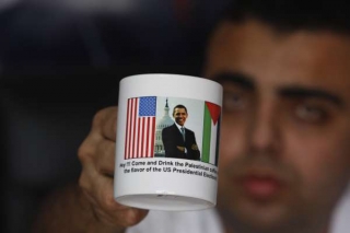 Sázka na Obamu. Palestinec s hrnečkem s obrázkem prezidenta USA.