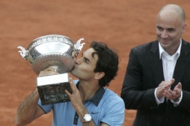 Roger Federer líbá pohár, v pozadí legendární Andre Agassi.