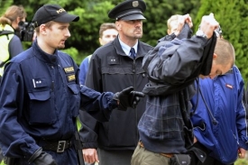 Policie kontroluje jednoho z účastníků jihlavské demonstrace.