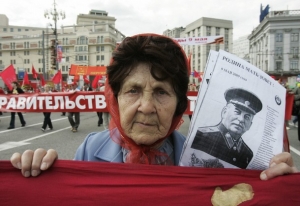 Komunistická protestující v Moskvě s portrétem Stalina.