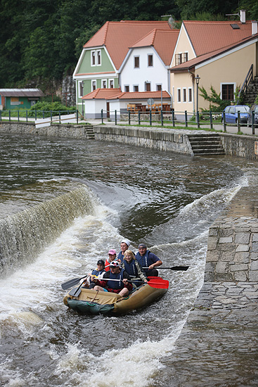Vodáci pokoušejí štěstí a sjíždějí jez na Vltavě.