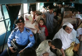 Policejní eskorta doprovází vládní autobus s uprchlíky zpět do Svátu.