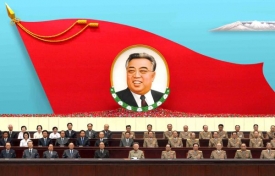 Kim Čong-Il řeční pod podobiznou svého otce Kim Ir-sena