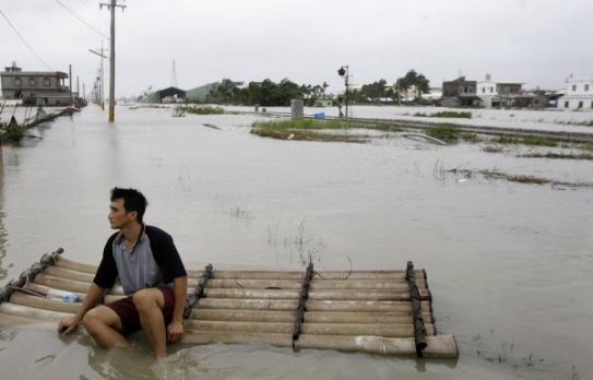 Mladý Číňan hledí na svůj zatopený domov.