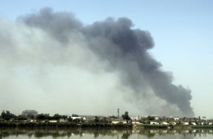 Sloup černého kouře po výbuších nad Bagdádem.