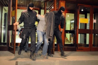 Španělští policisté odvádějí podezřelého teroristu.