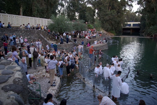 Křtům v Jardenitu přihlížejí zástupy věřících.