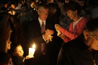 John McHugh a jeho žena zapalují svíčku.