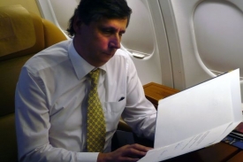 Premiér Jan Fischer si v letadle prohlíží českou ratifikační listinu.