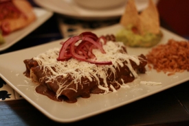 Enchiladas plněné kuřecím masem s omáčkou mole.