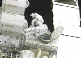 Aktuální záběr NASA TV: astronauti vystupují z ISS.