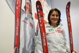 Nikola Sudová na tiskové konferenci pózuje s novými lyžemi.