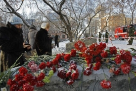 Lidé pokládají květiny na místo, kde došlo k tragickému požáru klubu.