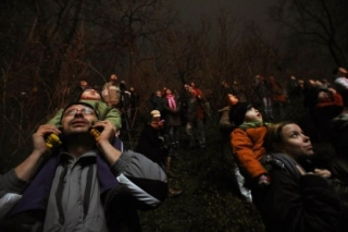 Pražané a návštěvníci metropole sledují ohňostroj nad Vltavou.