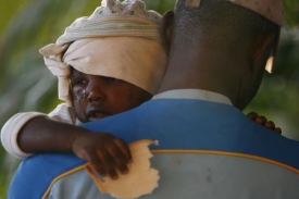 Muž odnáší dítě zraněné při zemětřesení na Haiti.