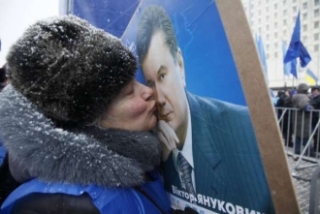 Fanynka Janukovyče líbá jeho plakát.