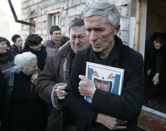 Otec Nodara Kumaritašviliho drží synův obrázek.
