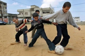 Chlapci v Gaze využívají pauzy v bombardování k hraní s míčem.