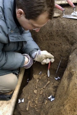 Antropolog Pavel Kubálek odkrývá kostru malého dítěte.