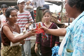 Barmánec rozdává svým postiženým krajanům jídlo.