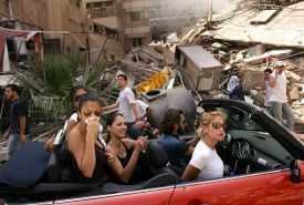 libanonská zlatá mládež projíždí rozbombardovanou čtvrtí v Bejrútu.