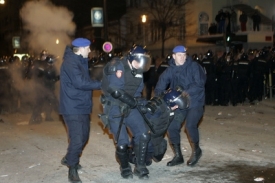 Policisté pomáhají kolegovi, kterého zranil dav před ambasádou USA.