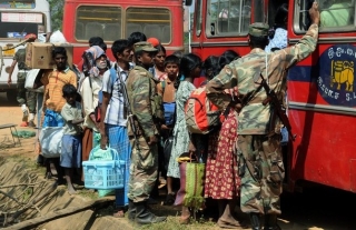 Uprchlíci nastupující do autobusů, které je převezou do táborů.
