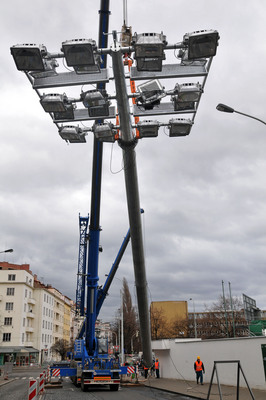 Technici vztyčují na stadionu Bohemians 1905 stožáry s osvětlením.