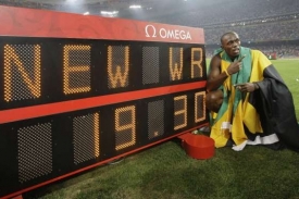 Jamajský sprinter Usain Bolt vedle cedule se světovým rekordem.
