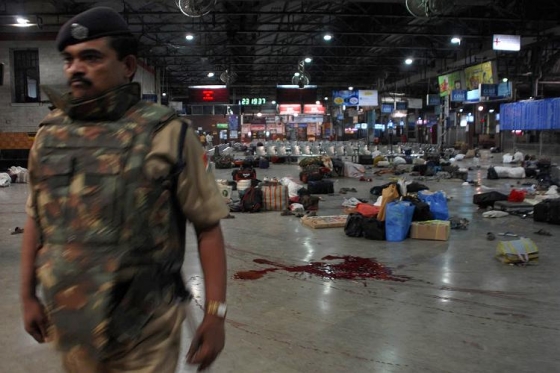 Policista zajišťuje misto činu po útoku na nádraží v Bombaji.