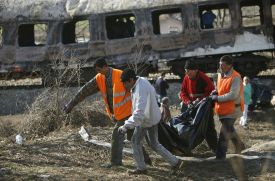 Záchranáři vynášejí mrtvé z vlaku