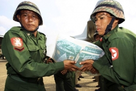 Vojáci překládají zahraniční pomoc z letadel v Rangúnu.
